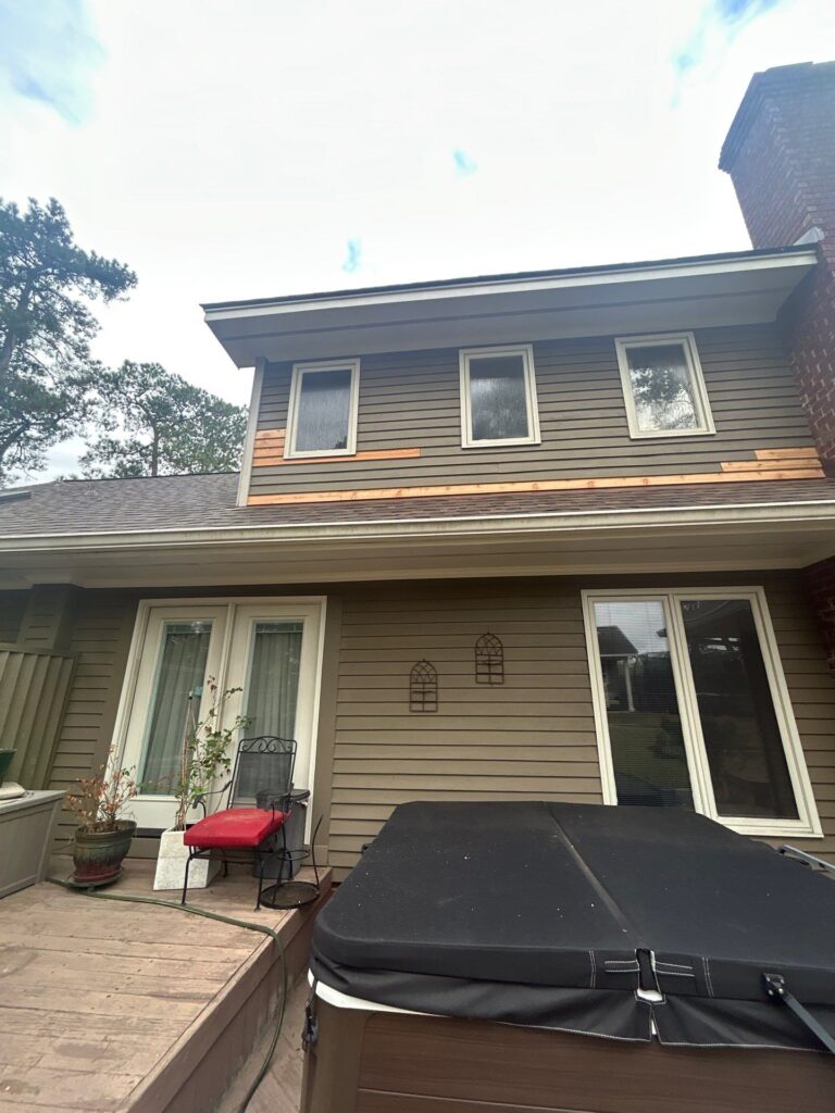 Modern home exterior featuring newly installed energy-efficient windows, enhancing curb appeal and comfort, with a hot tub and patio area visible below.